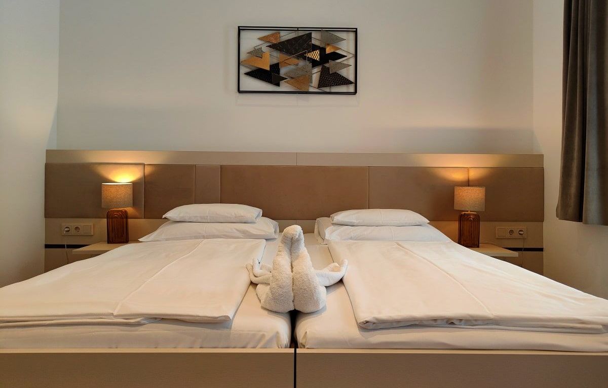 Hotel Gollner A hotel room with two beds and a painting on the wall