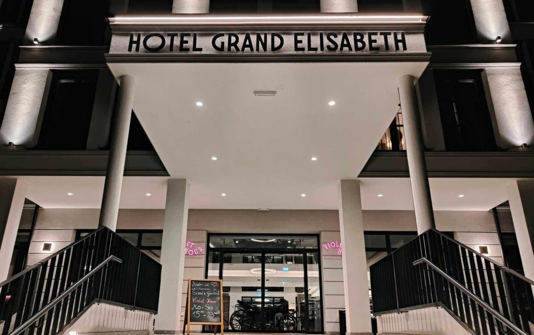 Grand Elisabeth Hotel Bad Ischl Eingang Hotel Grand Elisabeth entrance at night, lit with lights, featuring steps, and a sign.