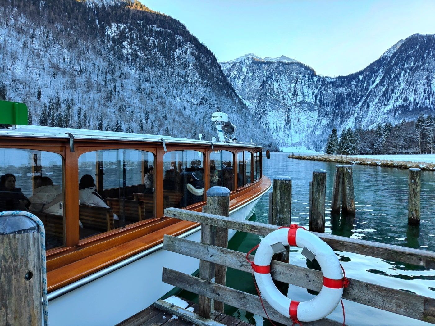Königssee Schifffahrt A boat is docked at a dock with mountains in the background