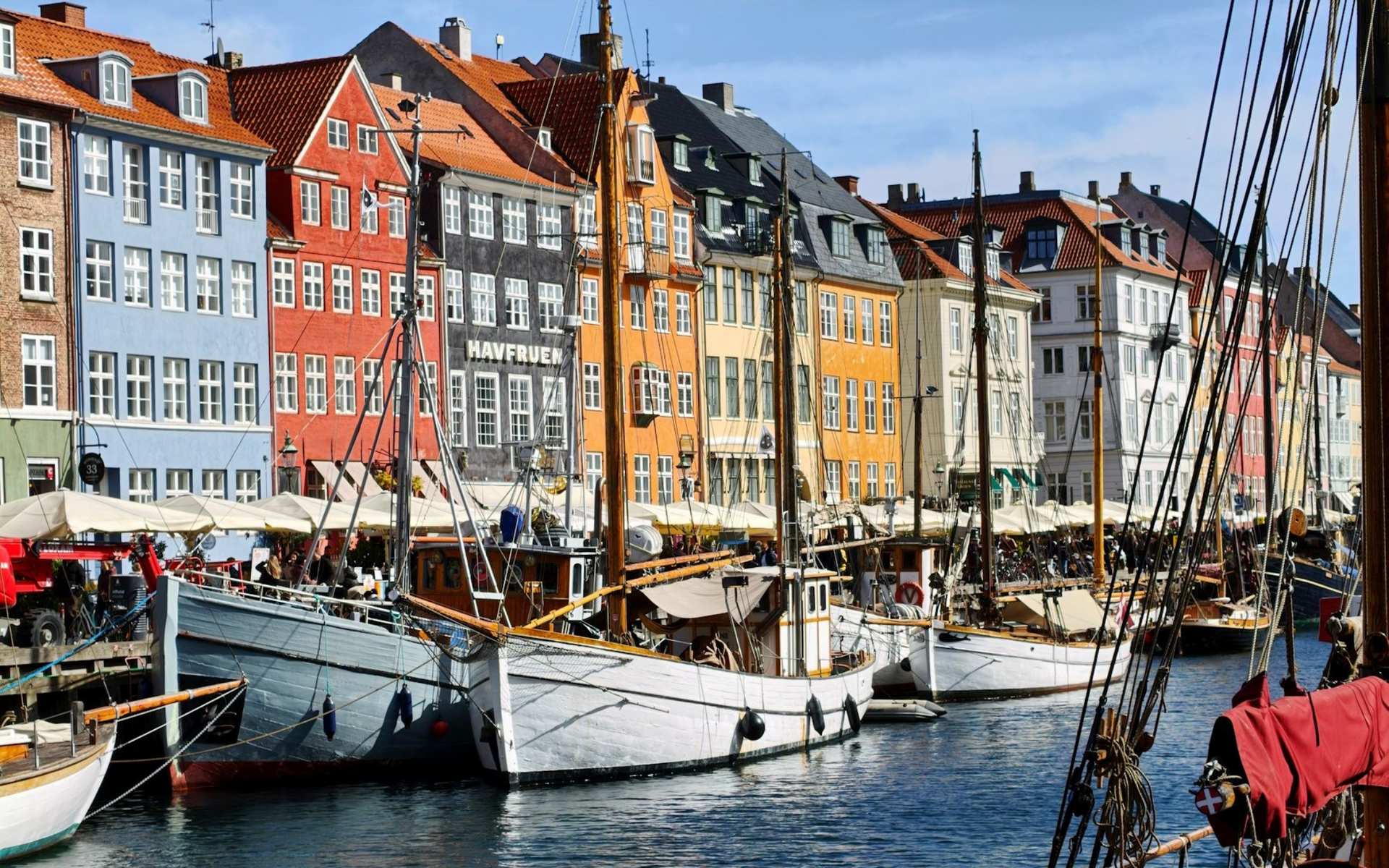 Kopenhagen Hafen Colorful waterfront buildings and sailboats lined along a busy harbor under a blue sky