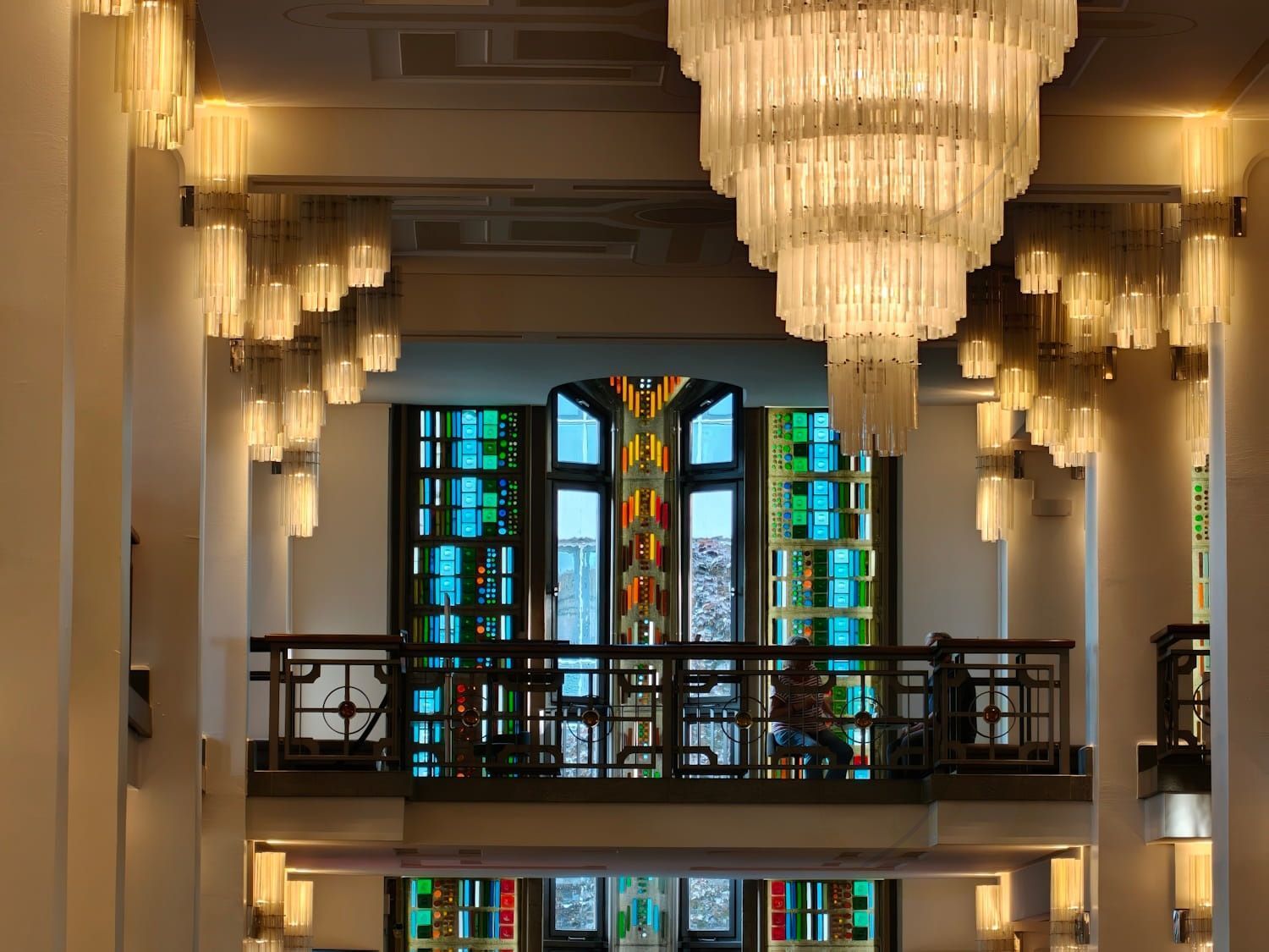 Friedrichstadt Palast Berlin Elegant hall with crystal chandeliers and a colorful stained-glass window above a balcony