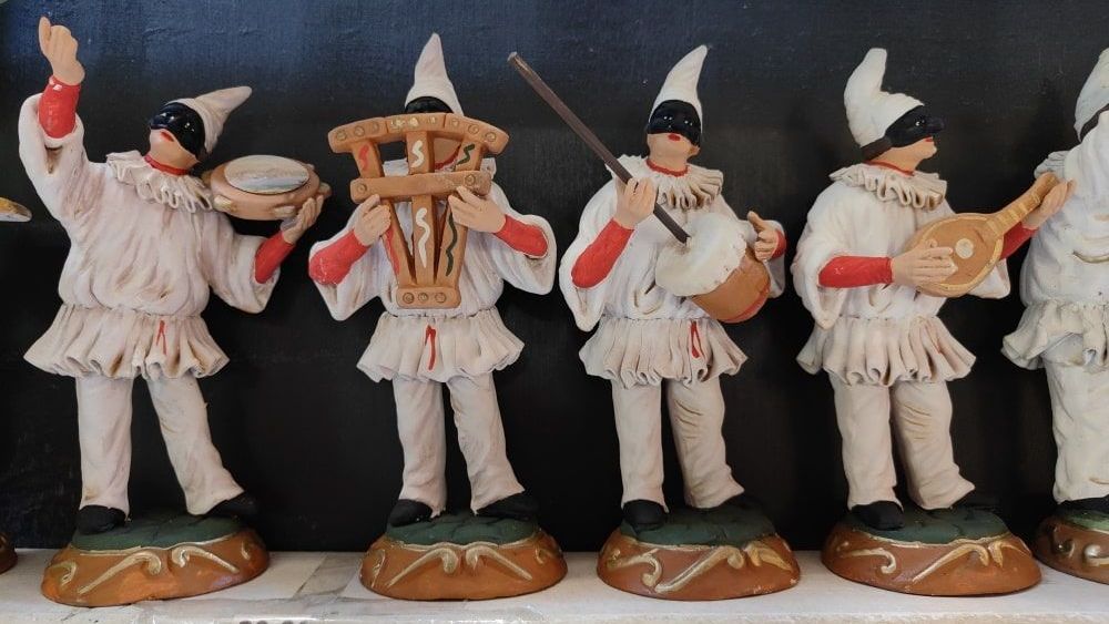 Pulcinella A group of figurines are standing in a row playing musical instruments