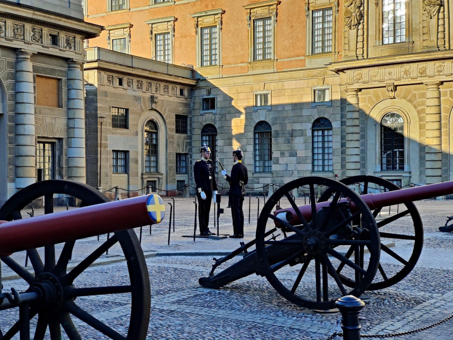 Cannon courtyard with two uniformed guards in front of a historic stone building