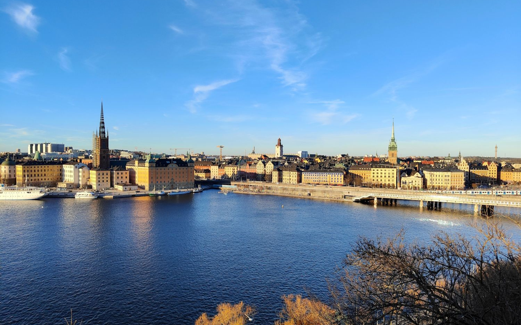 Stockholm Aussicht Panoramic city skyline across a river under a clear blue sky at sunset