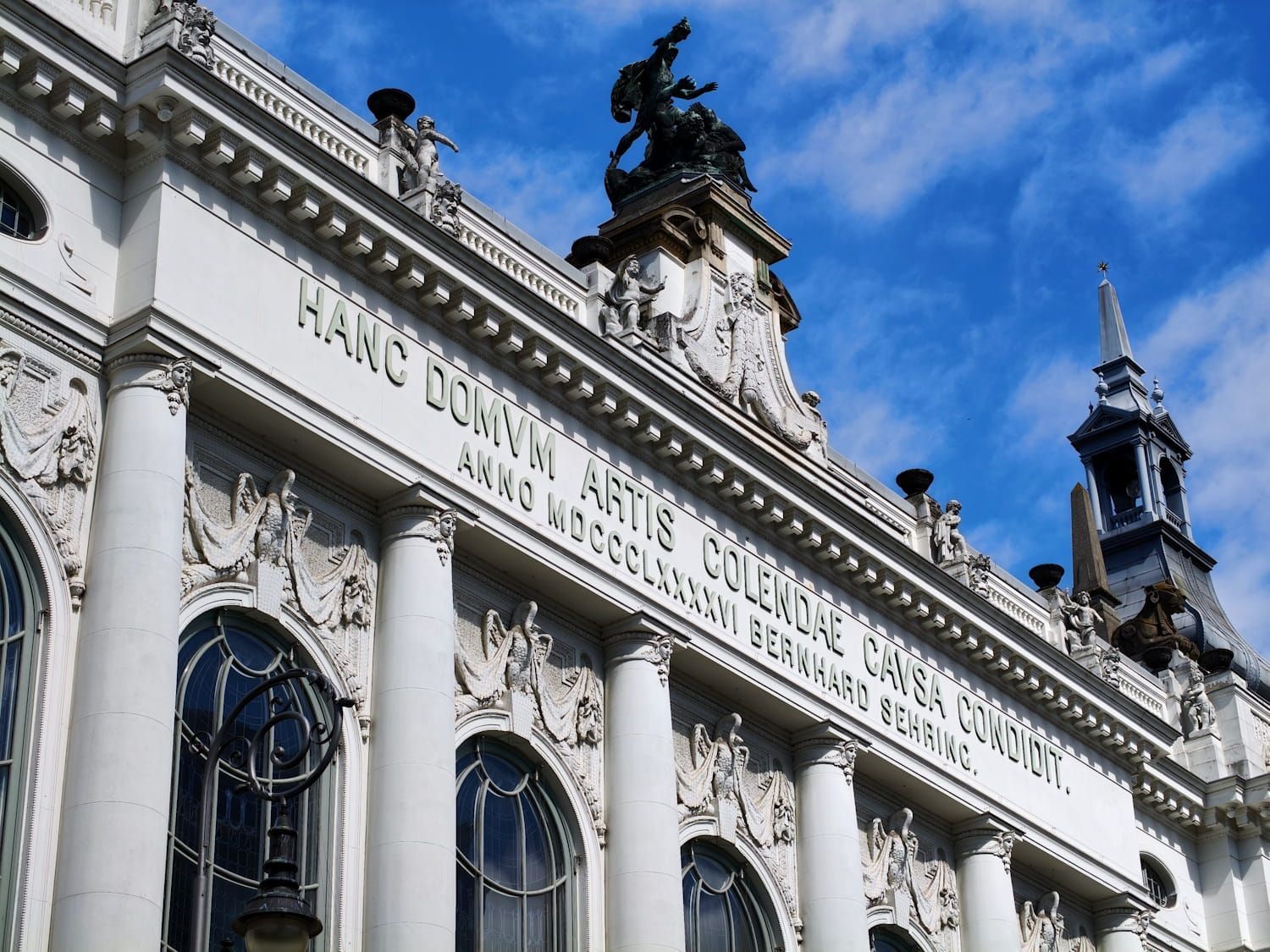Theater des Westens Berlin White ornate building façade with arched windows, decorative sculptures, and blue sky above