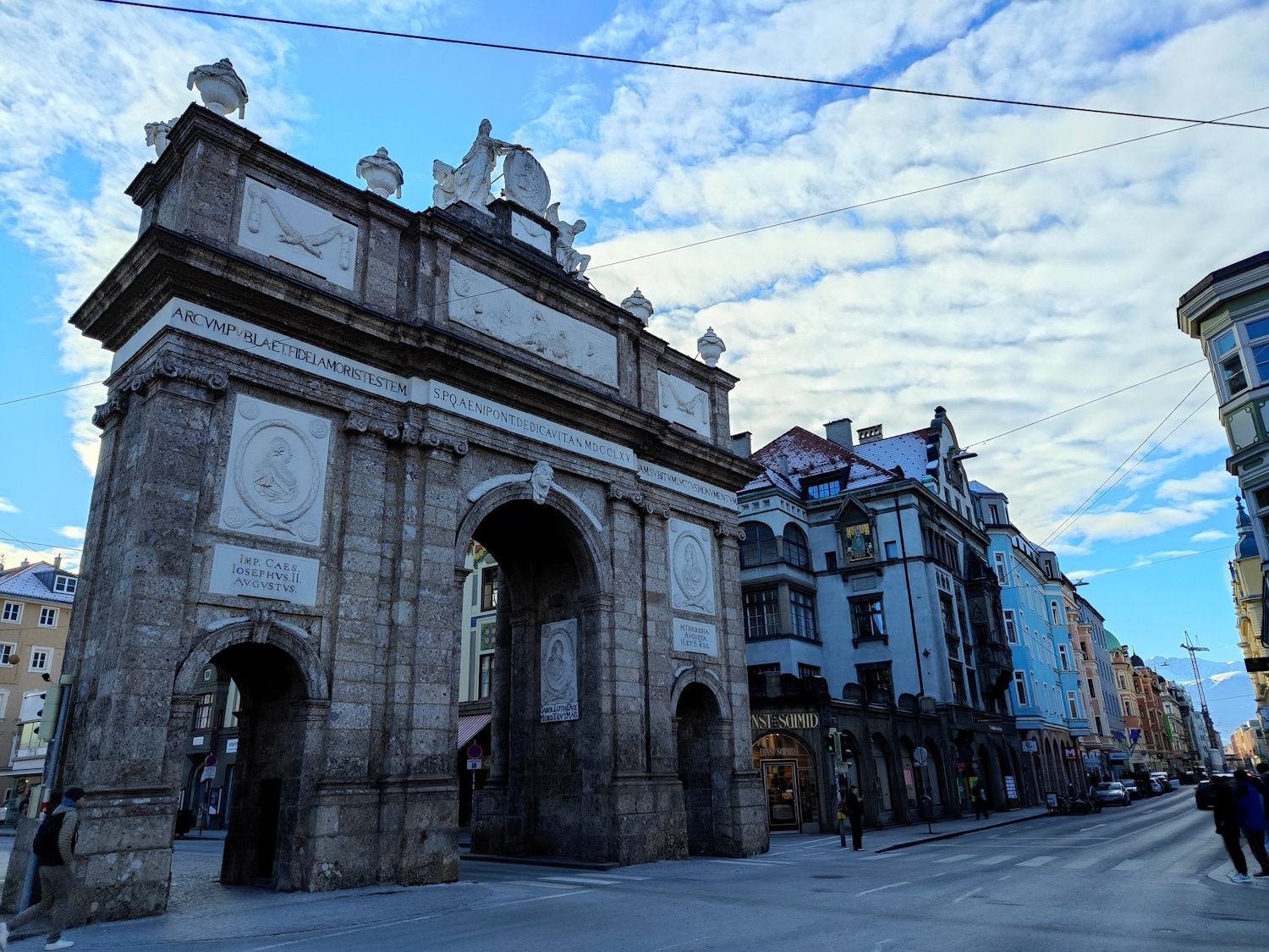 Triumphpforte Innsbruck Triumphal arch of Innsbruck, Austria, with city street and cloudy sky background.