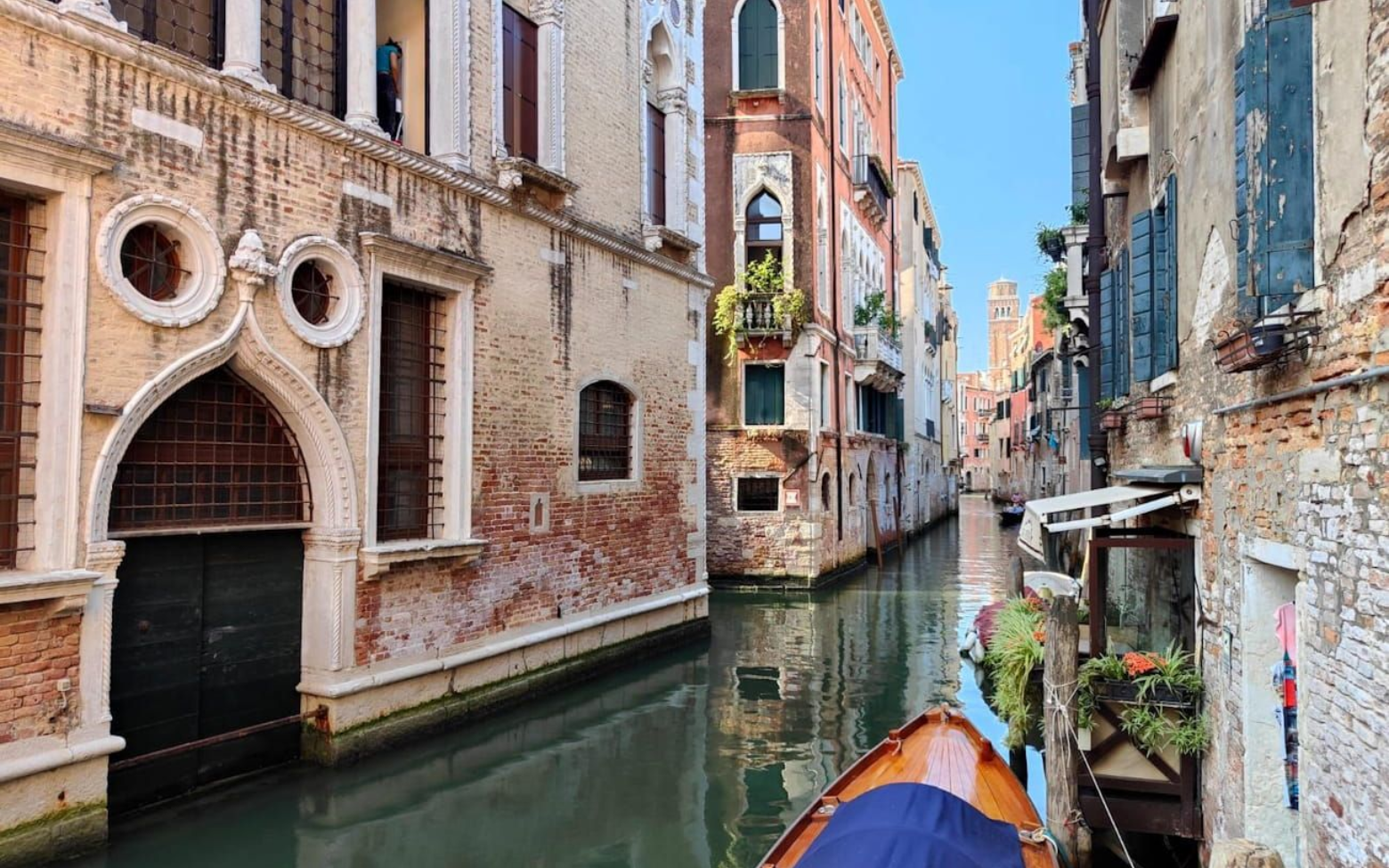 Ein Holzboot schwimmt auf einem schmalen Kanal in Venedig