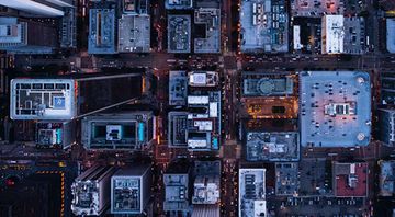 An aerial view of a city at night with lots of buildings.