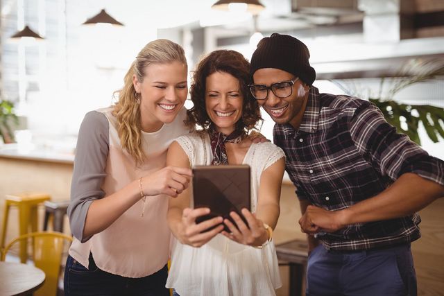 A group of people are looking at a tablet together.