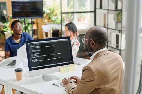 A man is sitting at a desk in front of a computer.