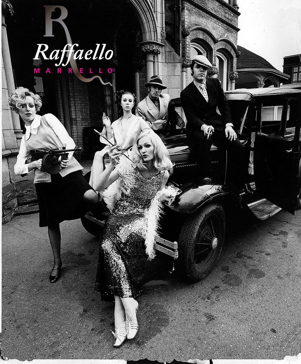 A group of people are standing in front of a car that says raffaello