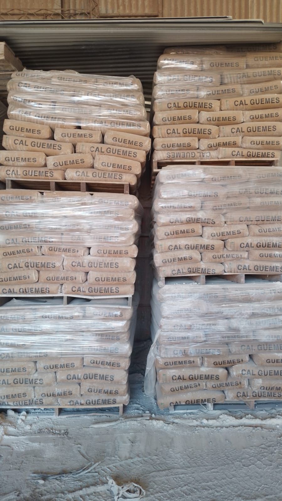 Un almacén lleno de montones de bolsas de cemento apiladas unas sobre otras.