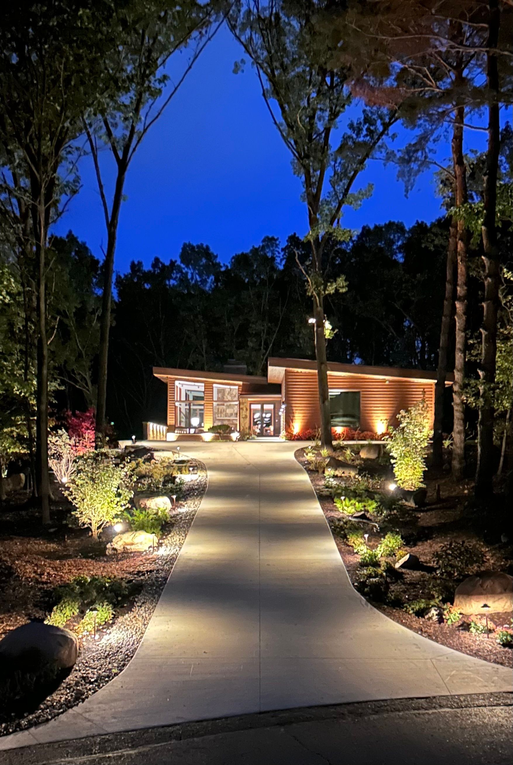 A driveway leading to a house is lit up at night