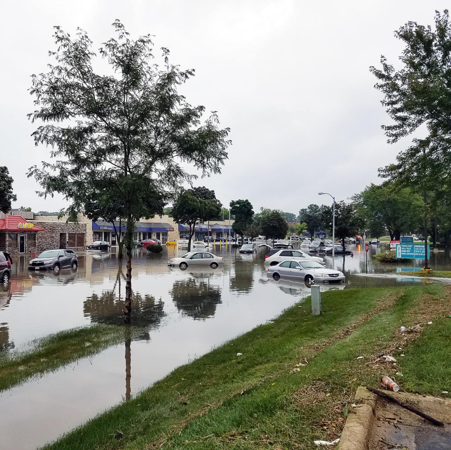 A flooded street with cars driving through it
