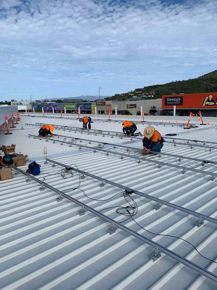 A Group Of People Are Working On The Roof Of A Building — Waltlec Industries In Garbutt, QLD