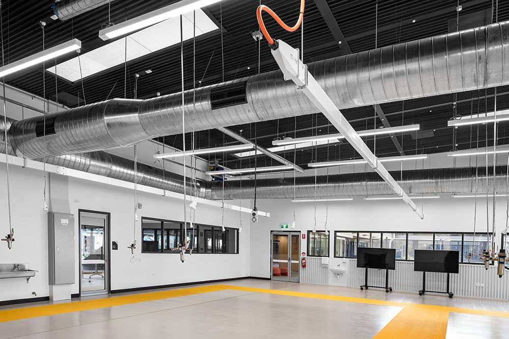A Large Empty Room with A Lot of Lights Hanging from The Ceiling — Waltlec Industries In Garbutt, QLD