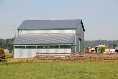 A barn is sitting in the middle of a grassy field.