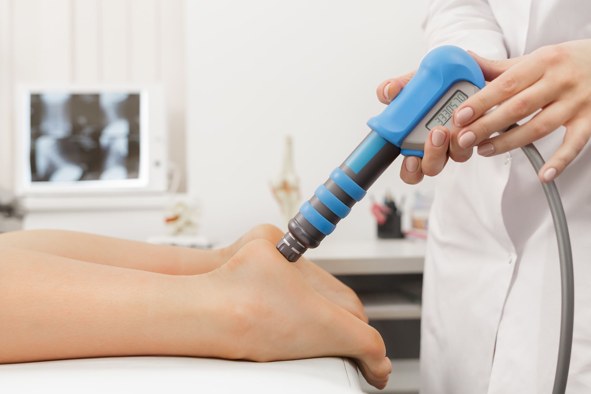 Blue shockwave therapy device treating a patient’s leg in a clinic Blue shockwave therapy device treating a patient’s leg in a clinic