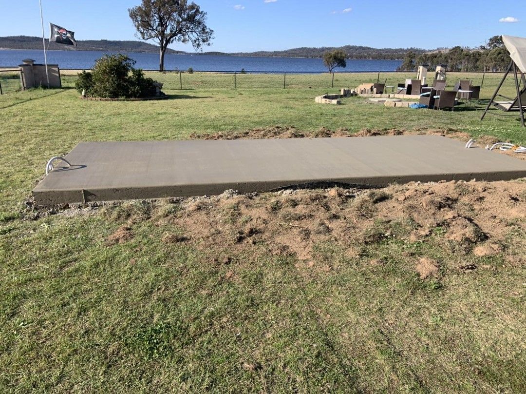 A Large Concrete Slab Is Sitting in The Middle of A Grassy Field — Pedro's Concreting in Highfields, QLD