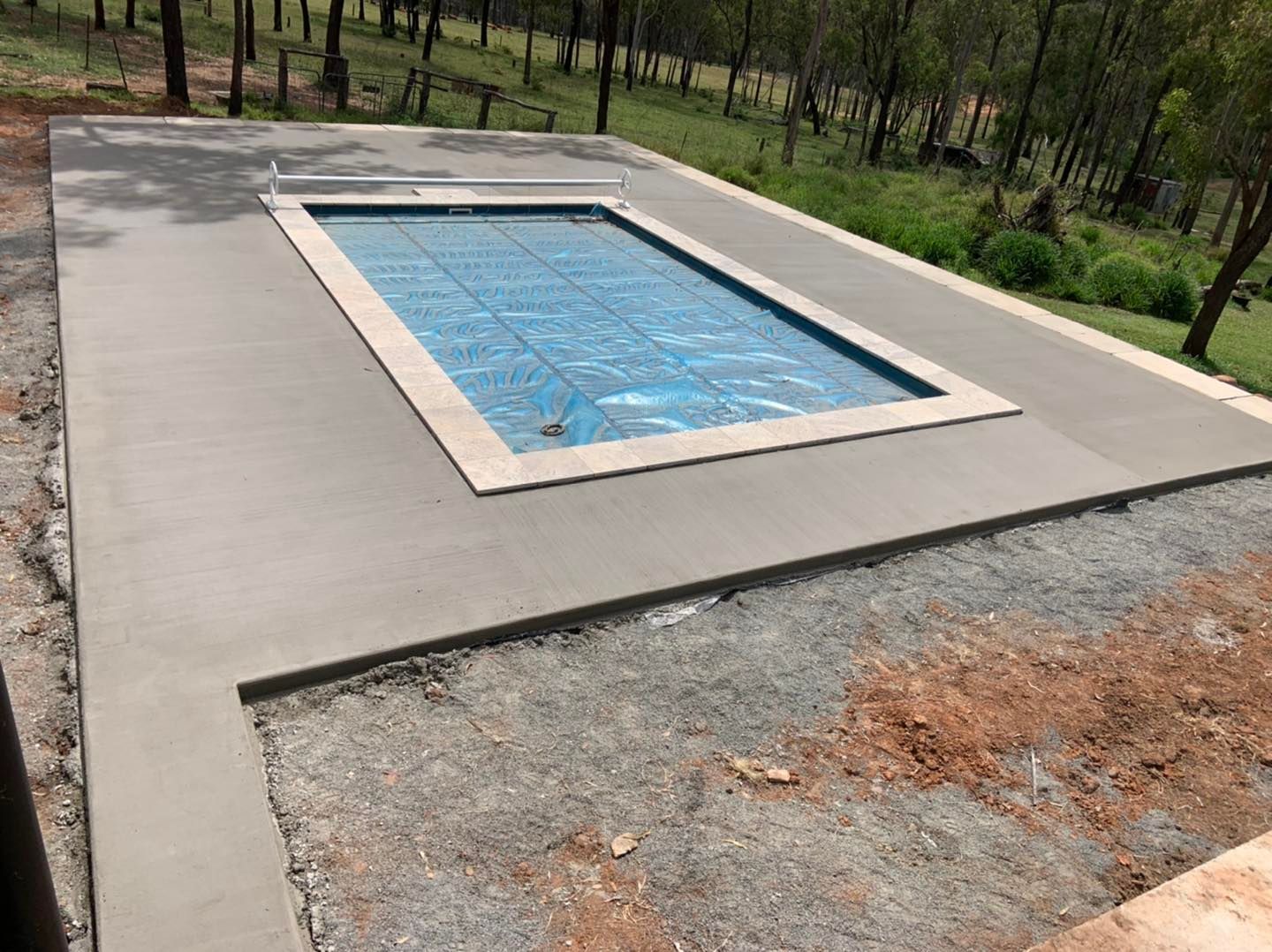A Large Swimming Pool is Sitting on Top of a Concrete Patio — Pedro's Concreting in Pittsworth, QLD