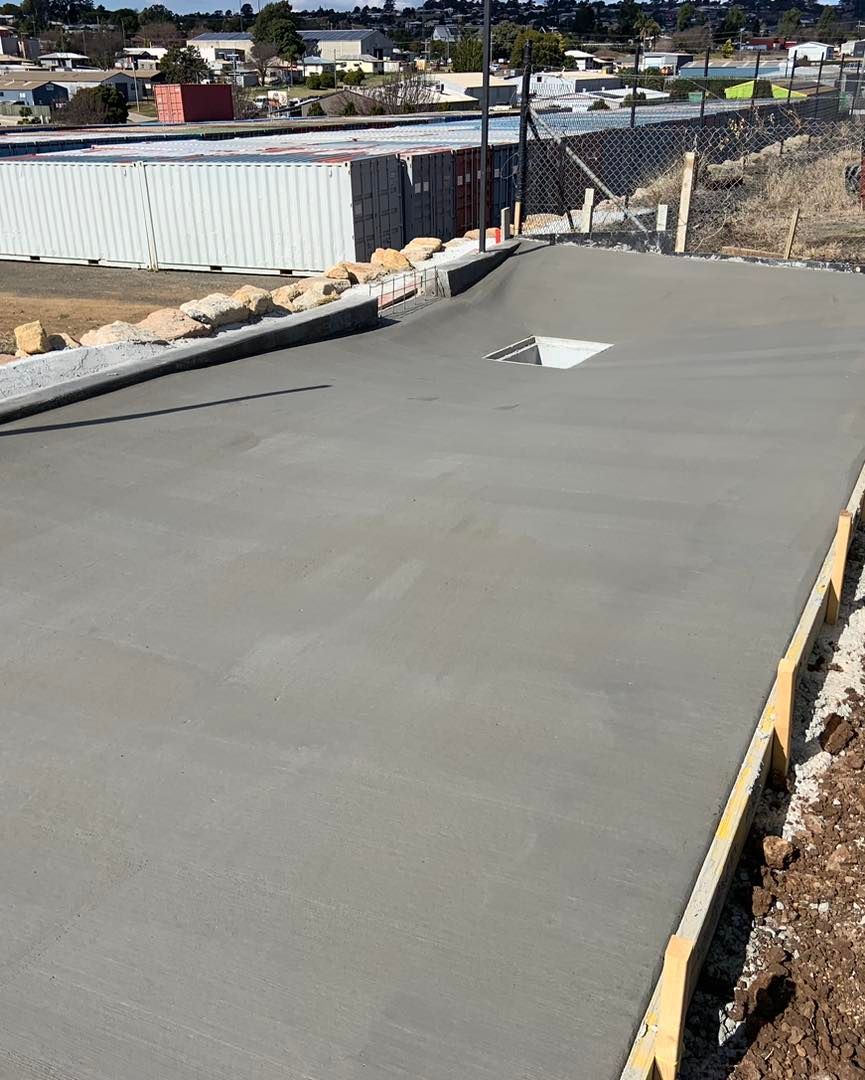 A Concrete Driveway is Being Built Next to a Building — Pedro's Concreting in Pittsworth, QLD