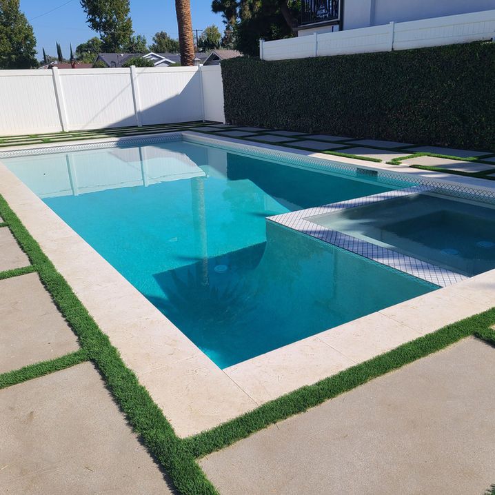 A large swimming pool with a white fence surrounding it