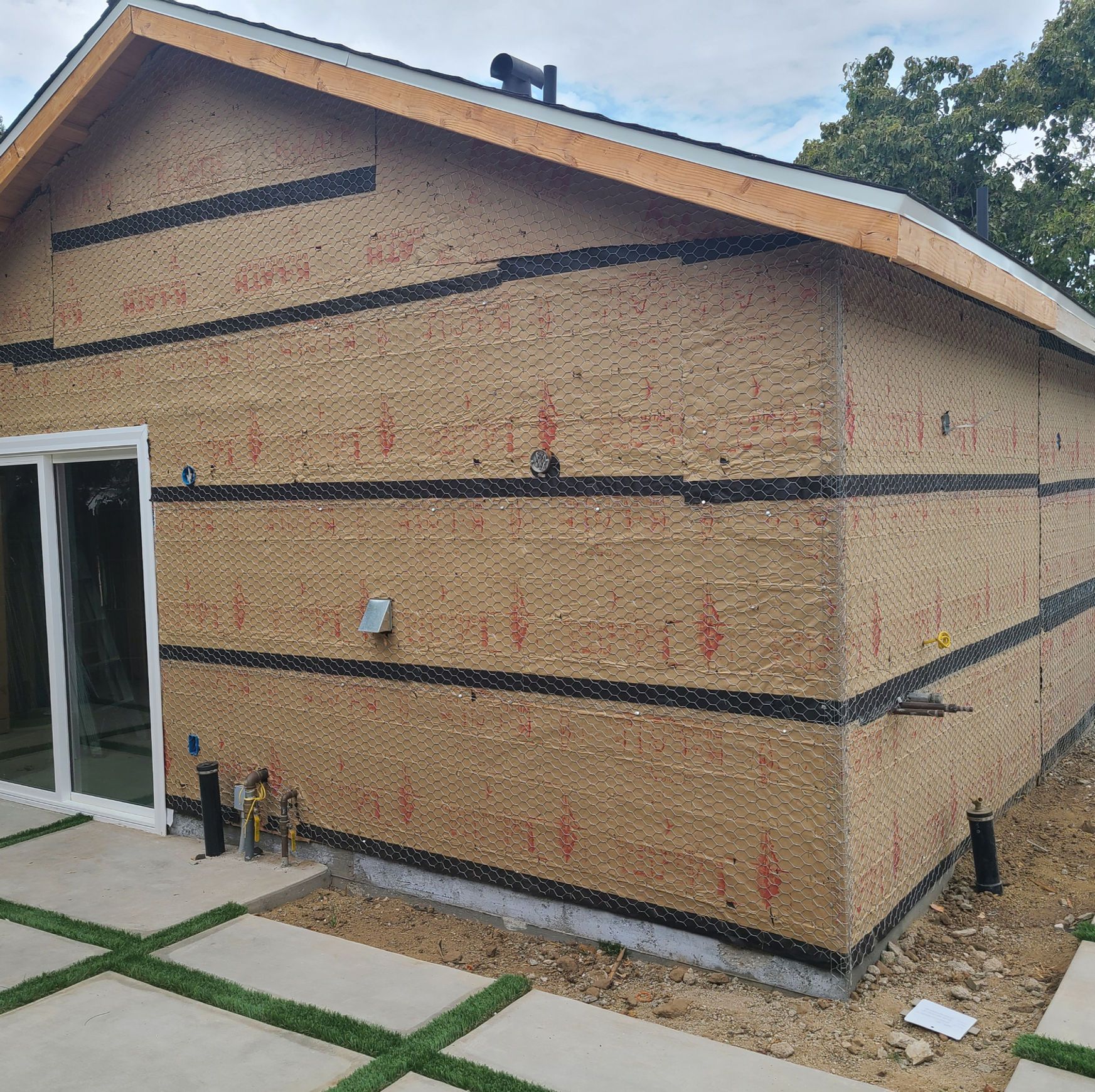 A house with a sliding glass door is being built.