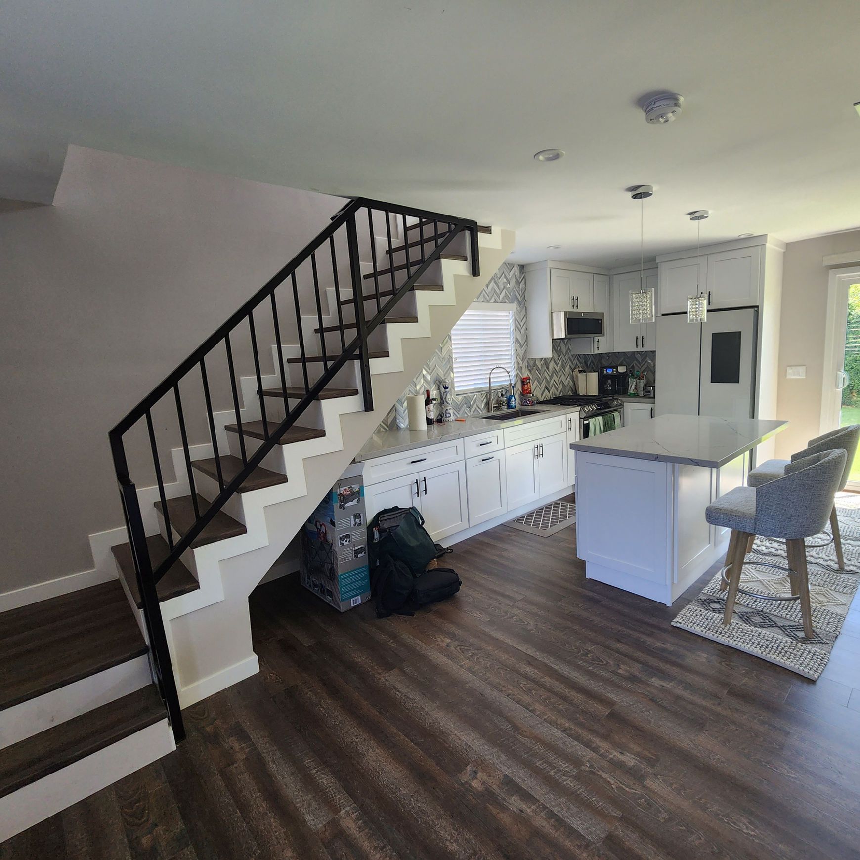 A kitchen with stairs leading up to the second floor