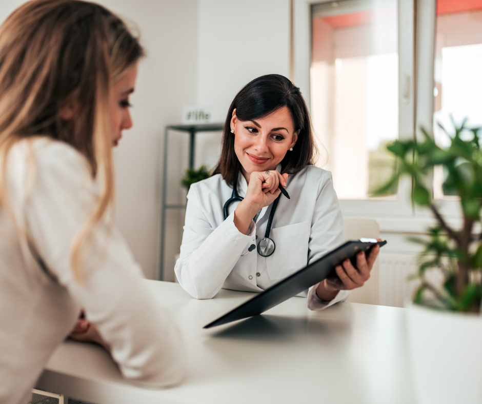 A doctor is talking to a patient while holding a clipboard.