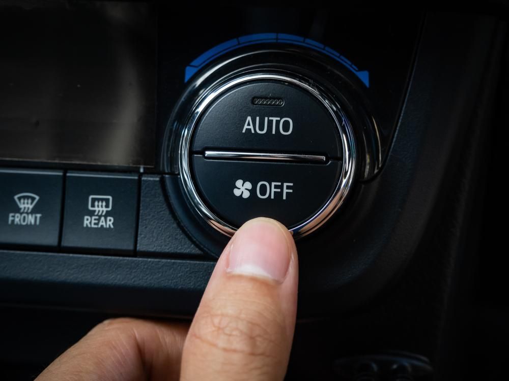 Person is Pressing the Auto Button on a Car Dashboard — Kirra Mechanical in Coolangatta, QLD