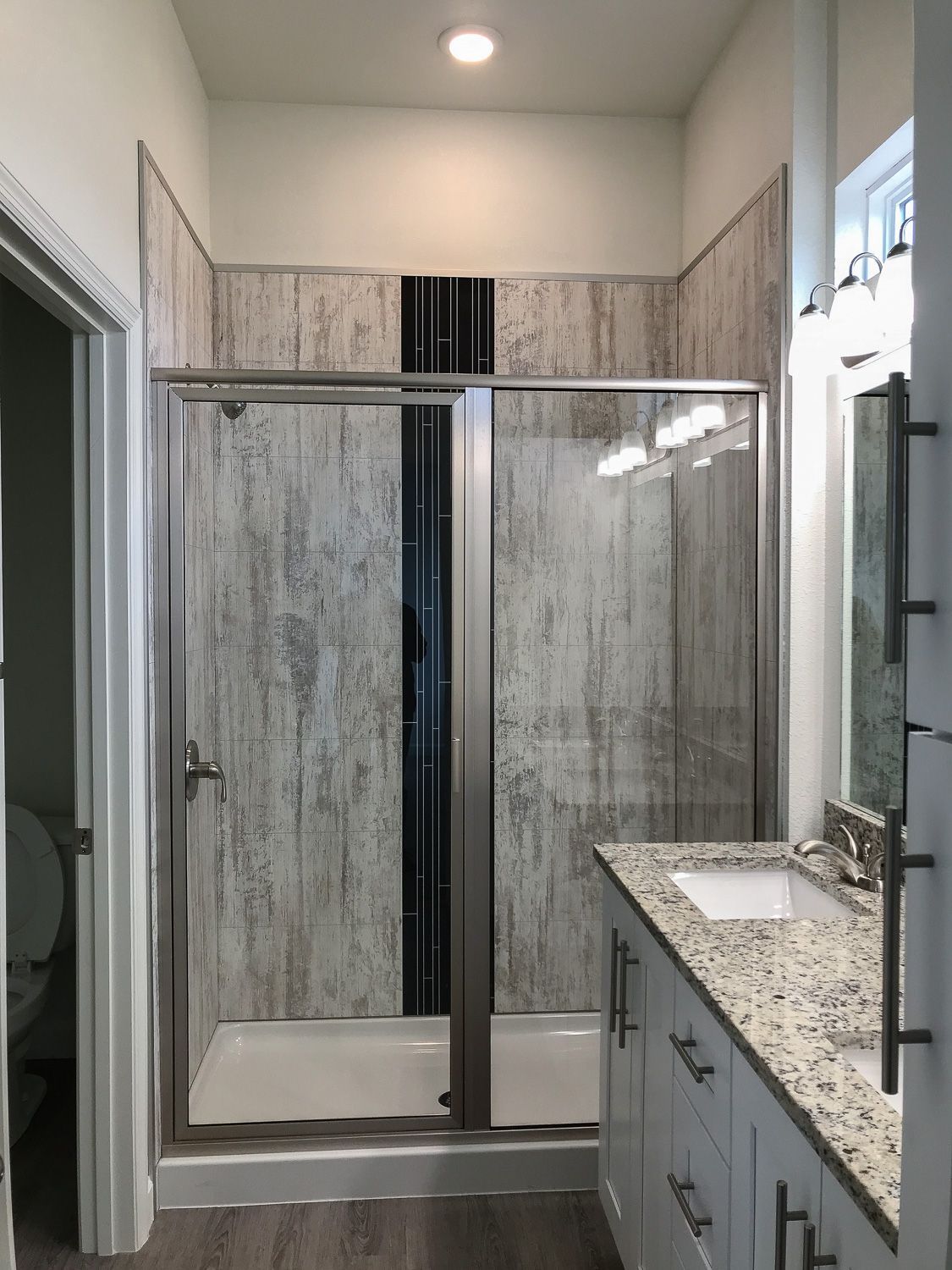 a bathroom with a walk in shower and a sink.