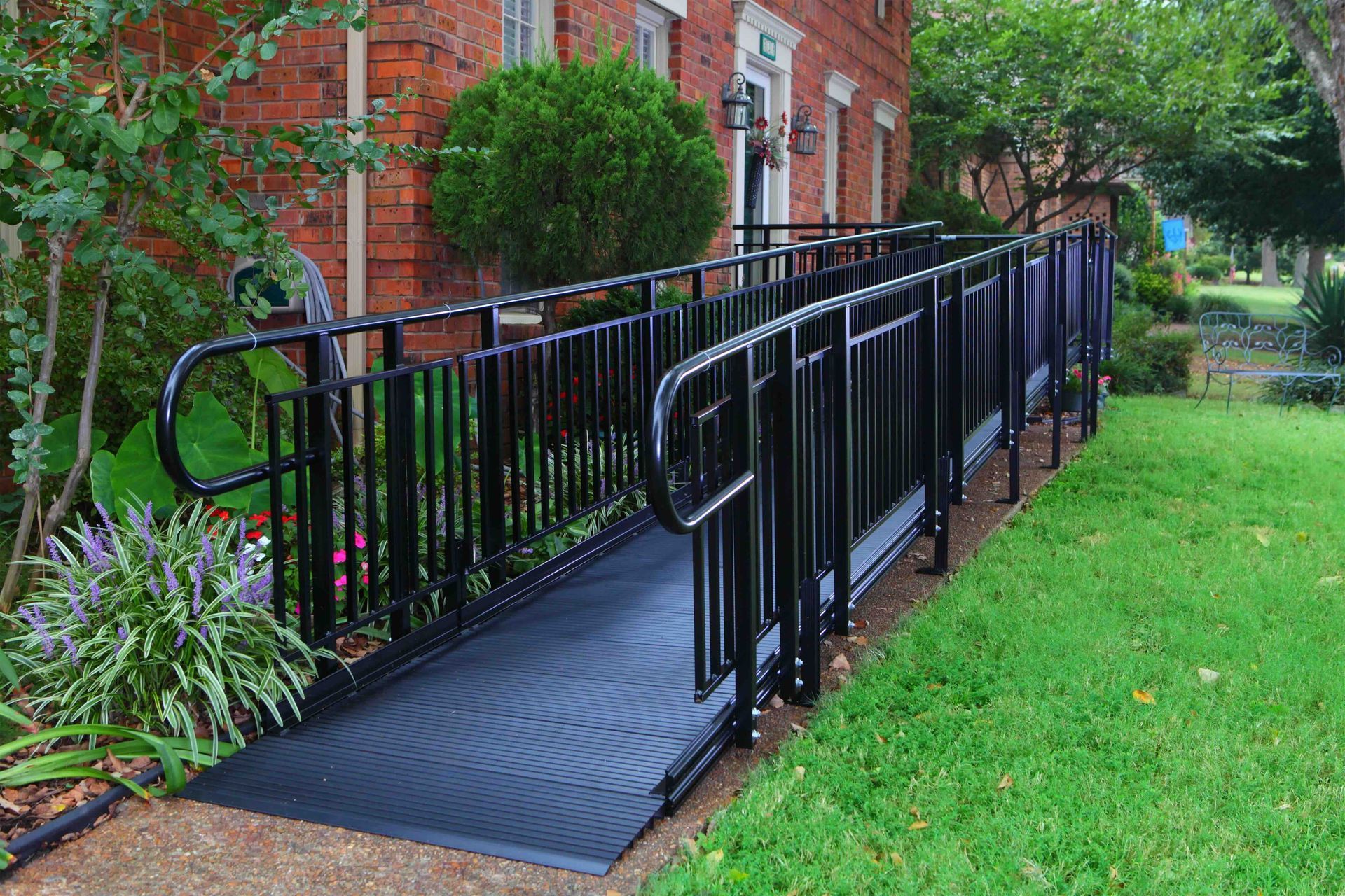 A black wheelchair ramp is in front of a brick building