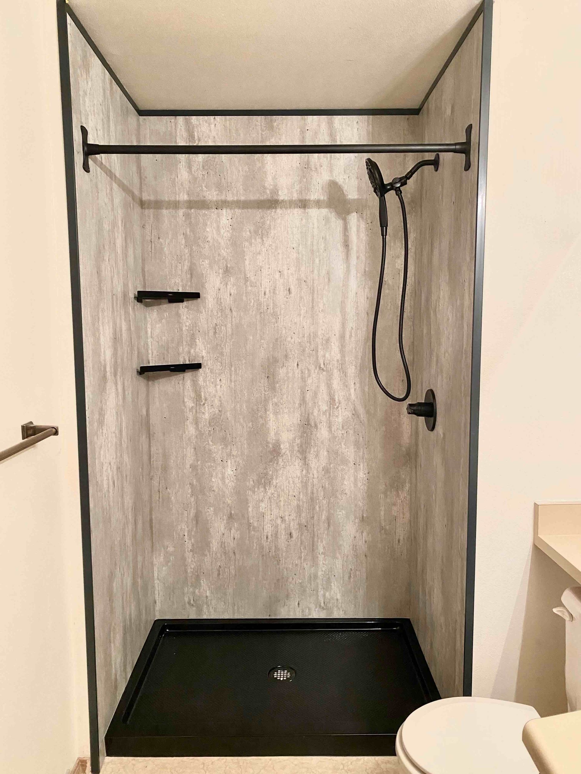 a bathroom with a shower stall and a toilet.