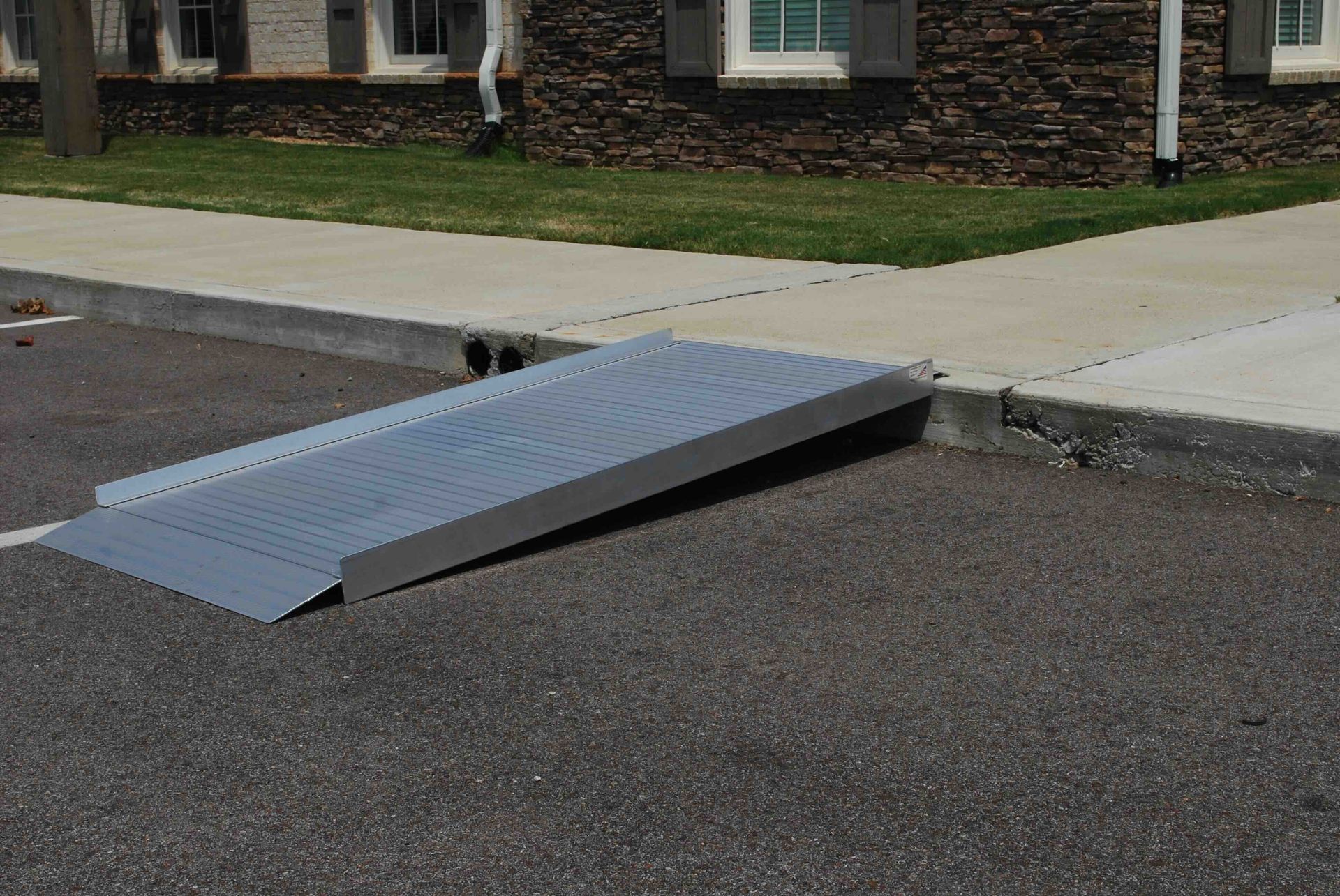 A ramp is sitting on the side of the road in front of a house.