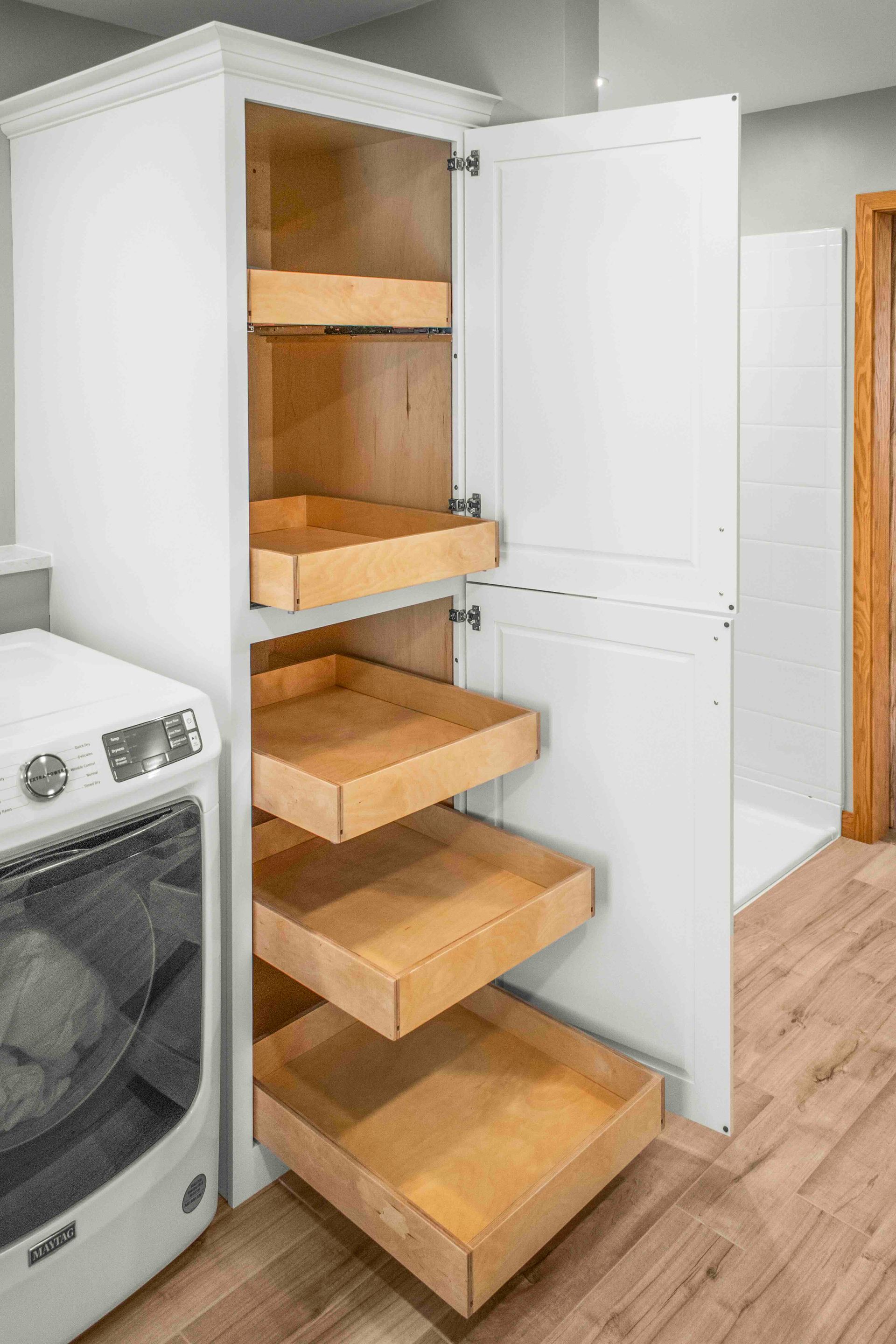 A laundry room with a washer and dryer and a cabinet with drawers.
