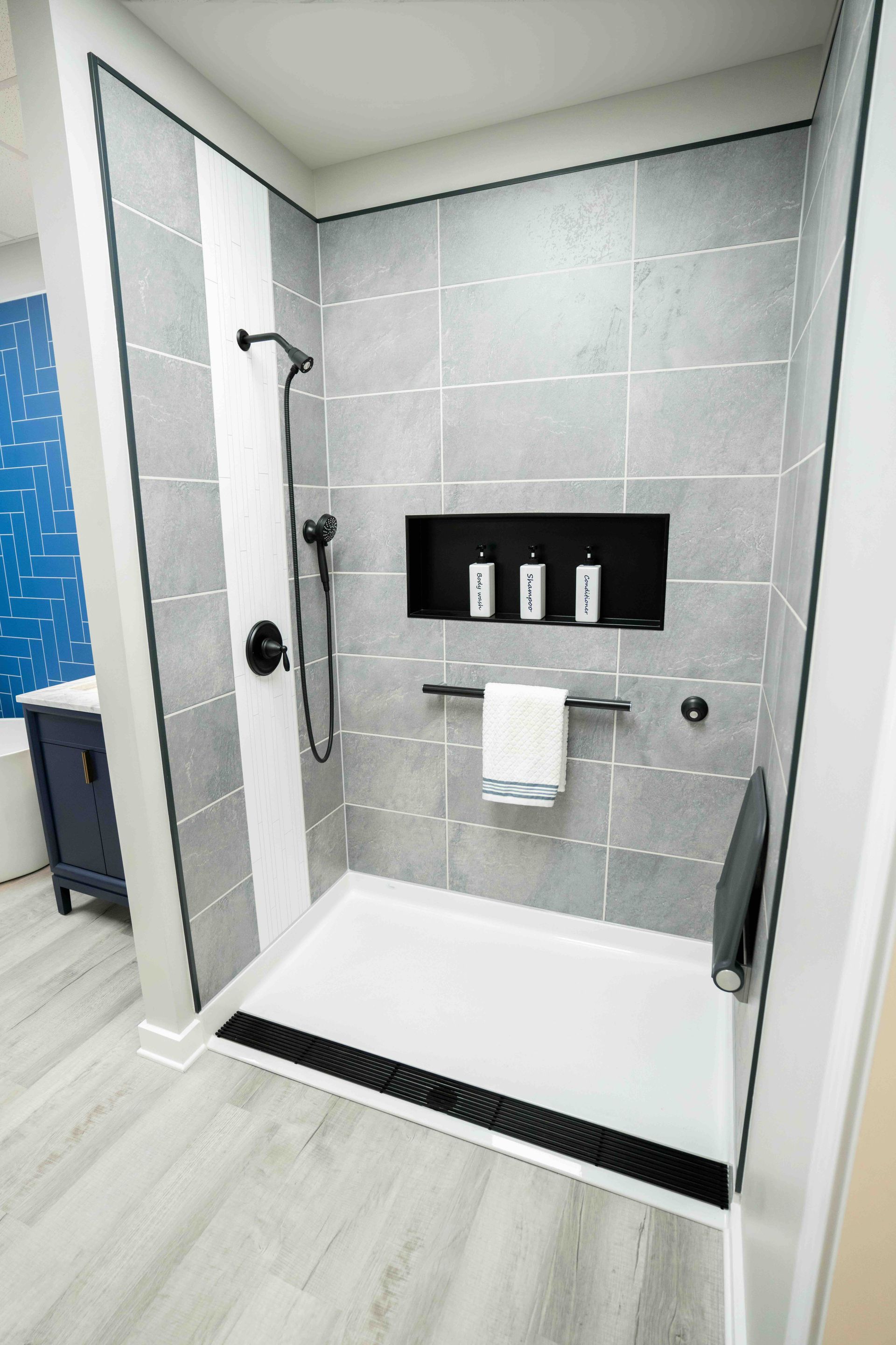 a bathroom with a walk in shower and a sink.