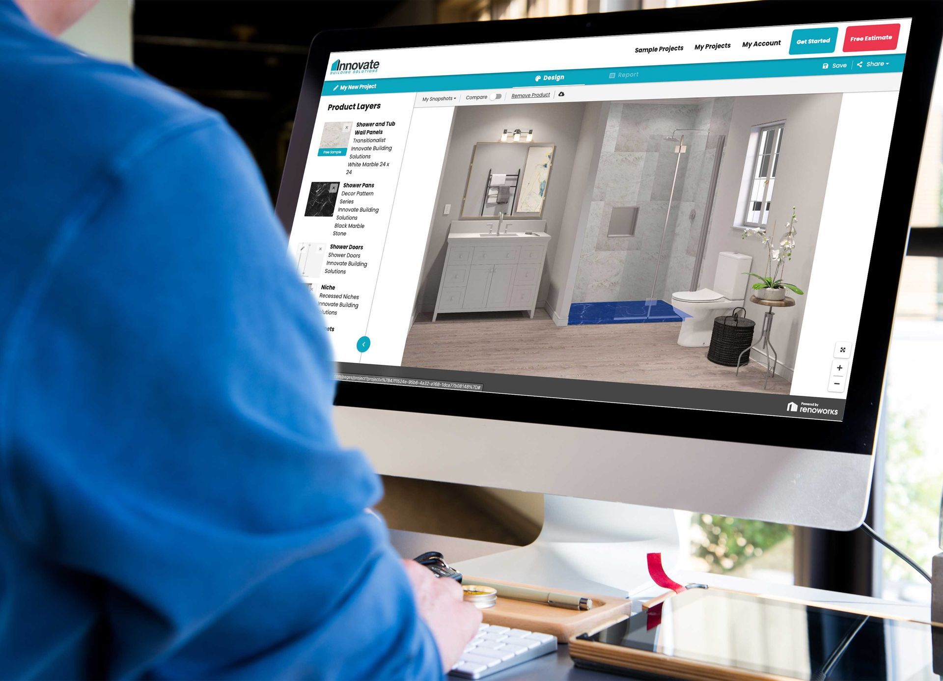 a man is using a computer to design a bathroom.