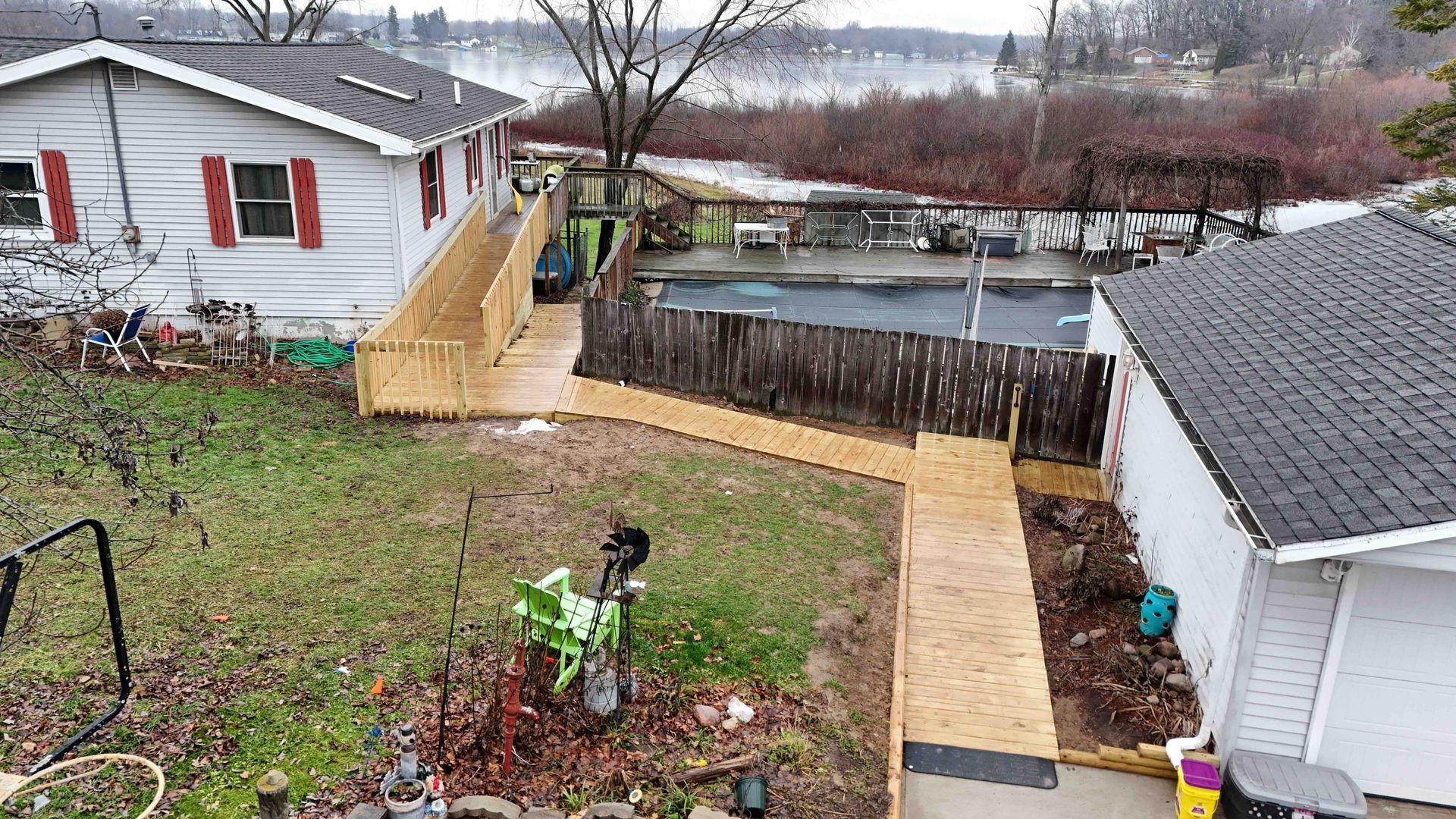 An aerial view of a house with a wooden walkway leading to a pool.