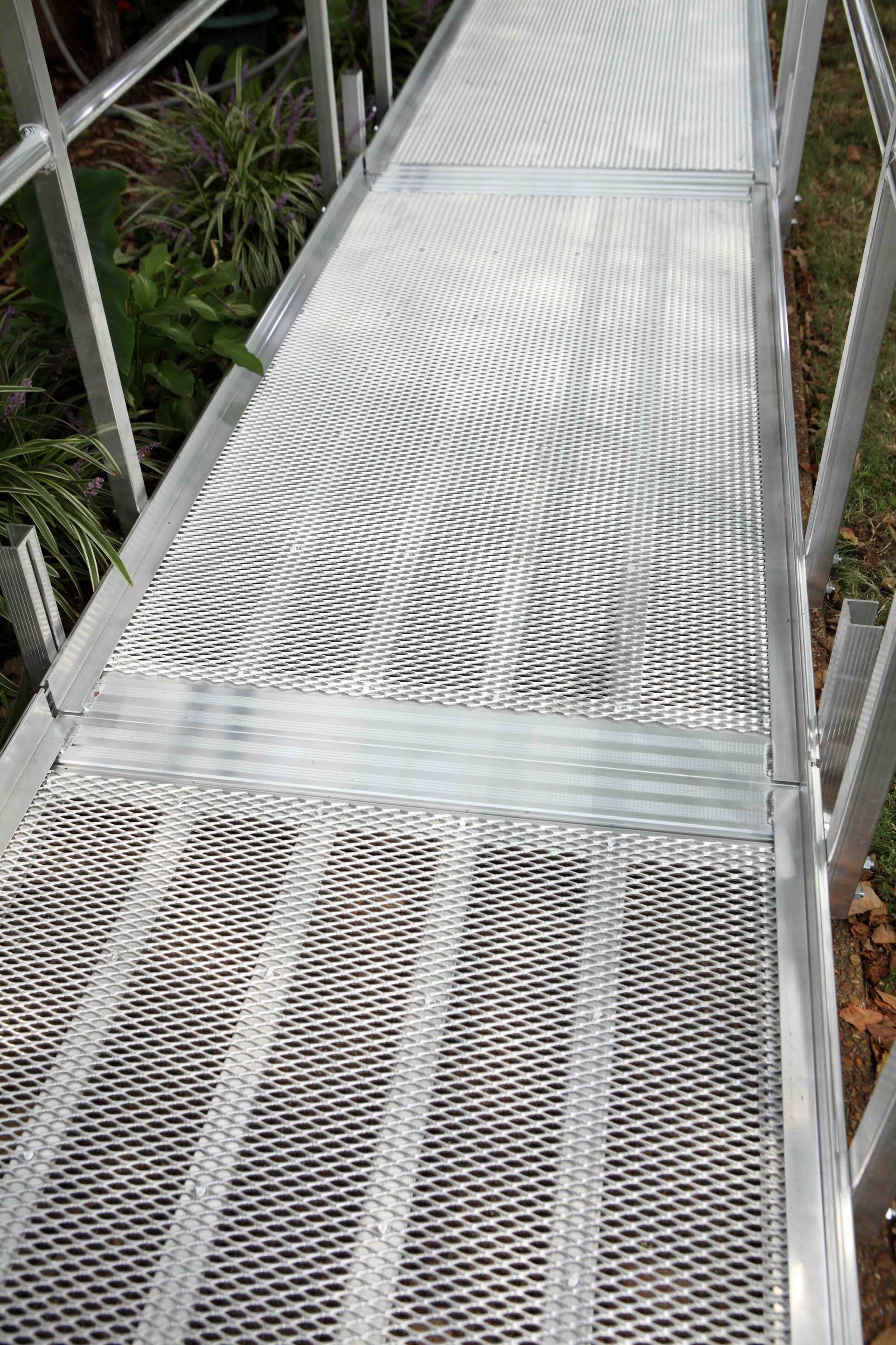 A close up of a metal walkway with stairs and a railing.