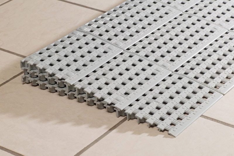 a stack of white tiles sitting on top of a tiled floor.