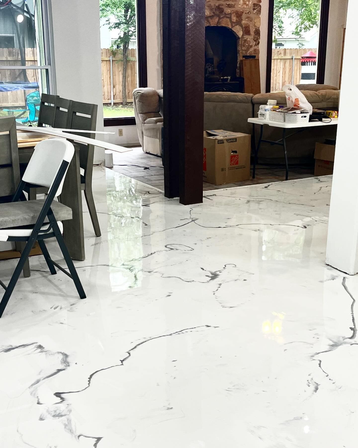 A living room with a marble floor and a table and chairs