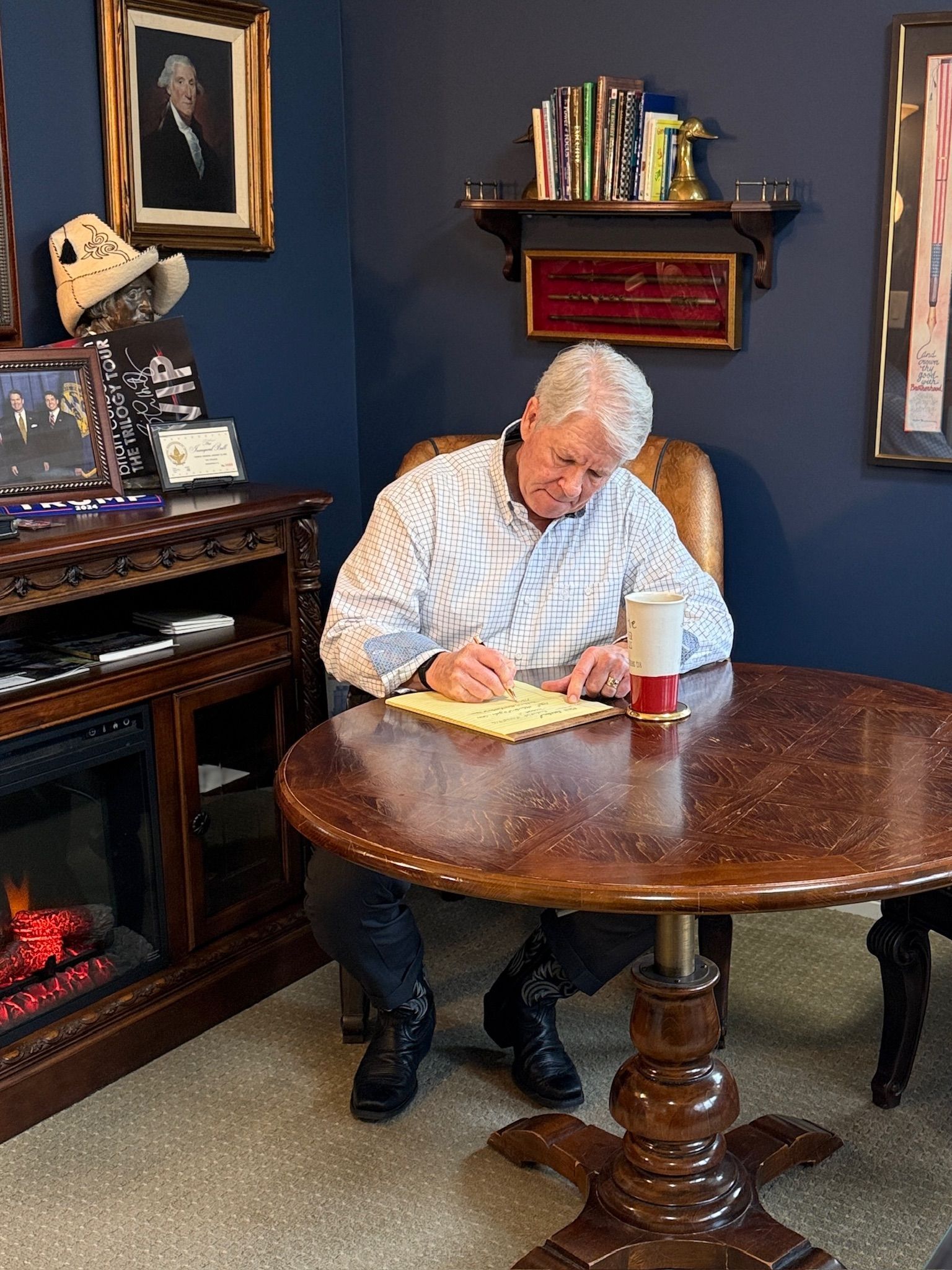 David Nabity writing at a round wooden table