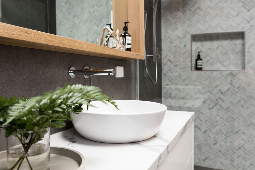 A Modern Bathroom With Marble Countertop With A Sink And A Shower - Darryl Tickle Building Pty Ltd In Alice River, QLD