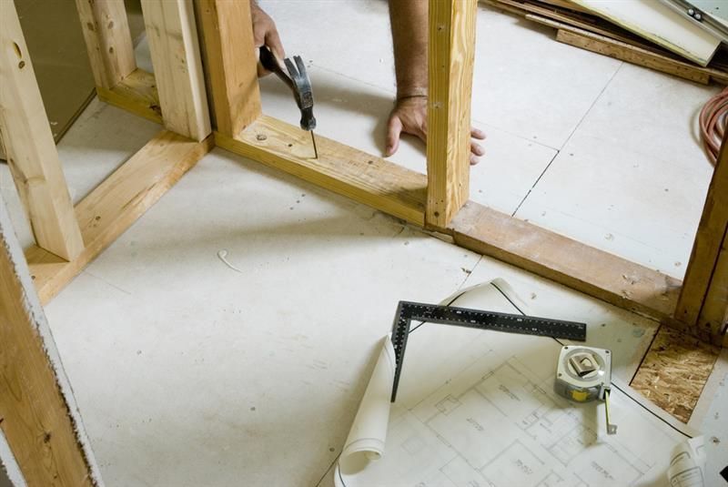 Wooden Scaffolding And Man Hammering A Nail — Darryl Tickle Building Pty Ltd In Alice River, QLD