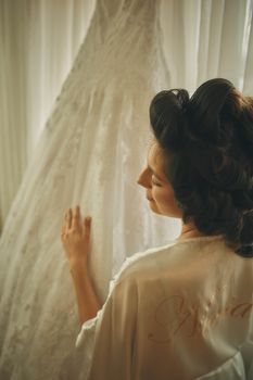 Bride with glowing skin getting ready in soft natural window light