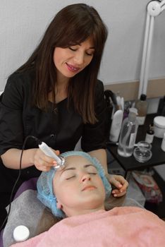Woman relaxing during a hydrating facial treatment in a calm clinic room