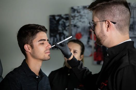 An aesthetic doctor marking a treatment grid on a patient's lower face