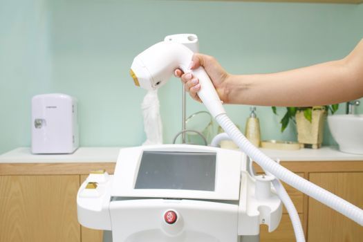 Doctor preparing a fractional laser device in a treatment room