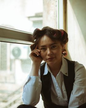 Woman with a rested look sitting by a window in morning light