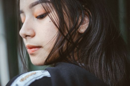 Profile of a woman's jawline with her hand resting on her cheek